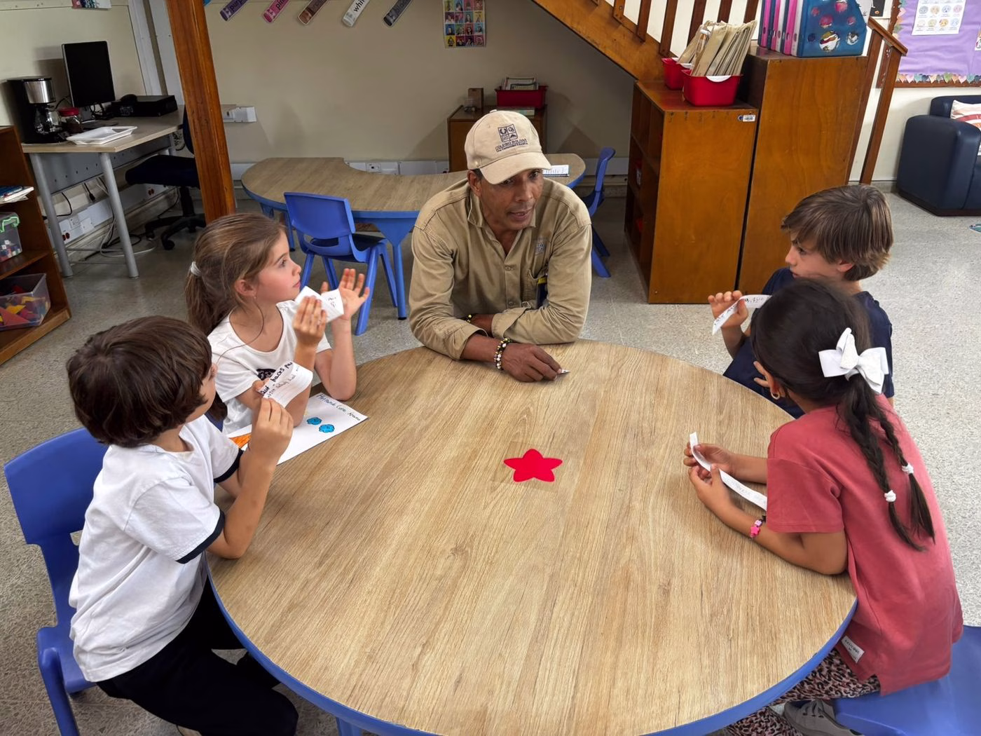 Colaborador conversando con niños en mesa